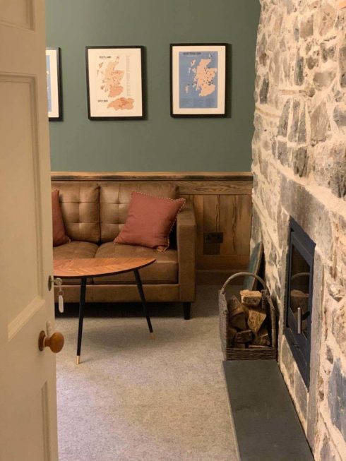 View from door of Craigellachie bar, with sofa and coffee table next to the fireplace