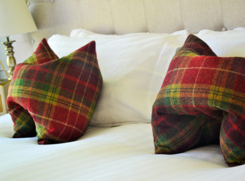 Details of red tartan cushions on bed in Fiddich room