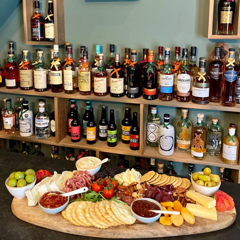 Bottles of spirits and beer on shelves in Craigellachie bar with cheese and meat board